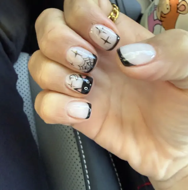 Halloween black French tips with spider web and cat nail art